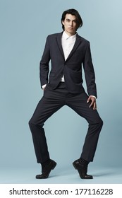 Young Businessman Posing On Tip Toe, Studio Shot