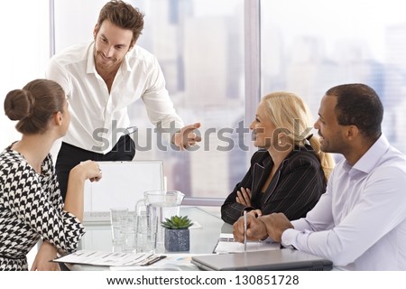 Young businessman presenting to partners in meetingroom.