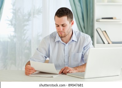 Young businessman reading a letter in his home office