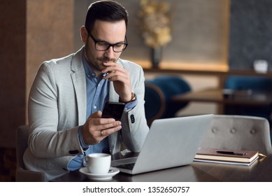 Young businessman reading a text message on smart phone.