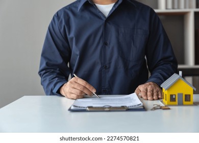 Young businessman, real estate insurance salesman reading and reviewing information Details of the agreement before signing the contract approval at home office investment and mortgage. - Shutterstock ID 2274570821