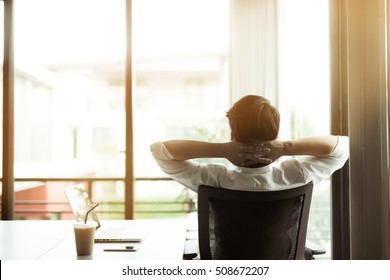 Young businessman relaxing at his desk in office
