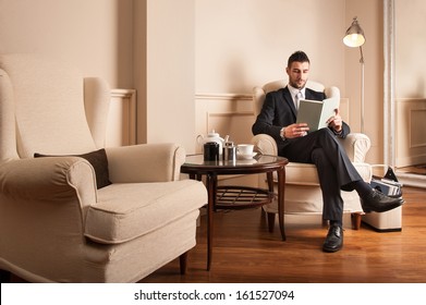 Young businessman relaxing reading a book sit on armchair.  - Powered by Shutterstock