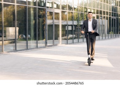 Young businessman riding an electric scooter for a business meeting in the office, office buildings, business man, electric transport, ecological transport, e-skateboard. Eco-friendly transportation - Powered by Shutterstock