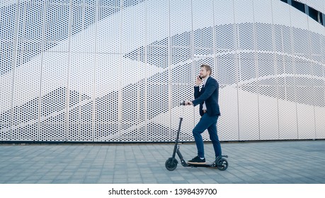 Young Businessman riding scooter and answering phone call. Transportation environmental concept. - Powered by Shutterstock