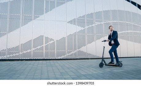 Young Businessman riding scooter and answering phone call. Transportation environmental concept. - Powered by Shutterstock