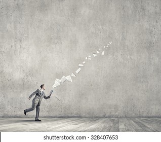 Young businessman running with book in hand and pages flying in air  - Shutterstock ID 328407653