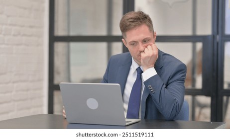 Young Businessman Shocked by Loss on Laptop - Powered by Shutterstock