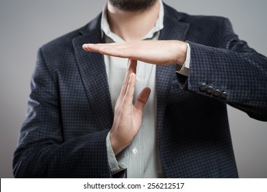 young businessman showing time out sign with hands against