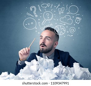 Young businessman sitting behind crumpled paper with mixed doodles over his head - Shutterstock ID 1109347991