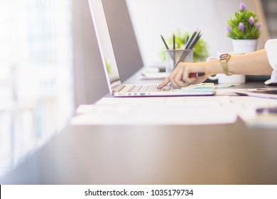 A young businessman is sitting by the window at his desk alone in the morning and sketching business plans on his notebook computer to study the way and find businessmen interested in investing. - Shutterstock ID 1035179734