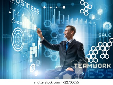 Young Businessman Sitting On Chair And Working With Virtual Panel