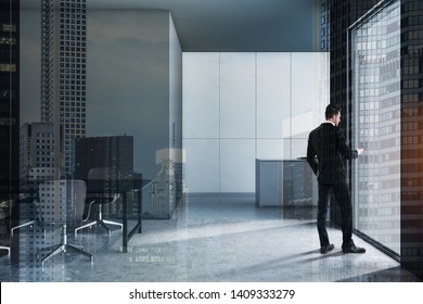 Young businessman with smartphone standing in modern kitchen interior with gray and white walls, gray countertop and dining table with chairs. Real estate market concept. Toned image double exposure - Shutterstock ID 1409333279