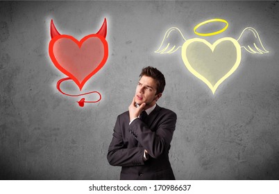 Young businessman standing and choosing between the angel and the devil heart