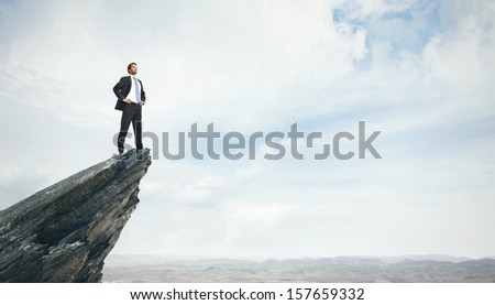 Young businessman standing on a peak