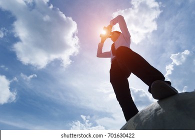 Young Businessman Standing Under The Sun And Looking Through Binoculars.
Leadership And Business Vision Concept.