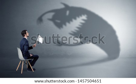 Young businessman staying and negotiate with a monster shadow