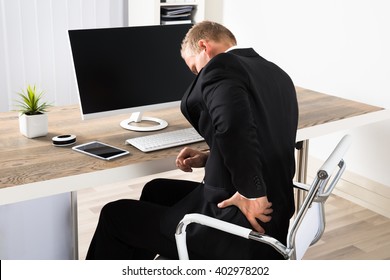 Young Businessman Suffering From Backpain While Working In Office