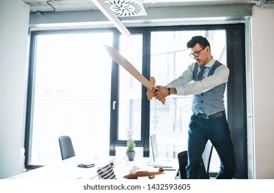 A Young Businessman With Sword In An Office, Having Fun. A Competition Concept.