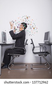 Young Businessman Throwing Confetti In The Office