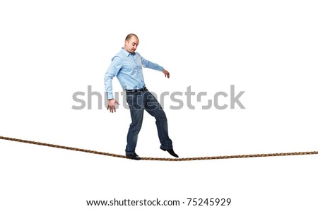 young businessman try to walk on rope