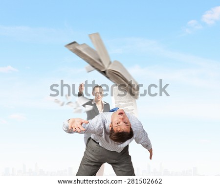 Young businessman trying to evade from thrown book