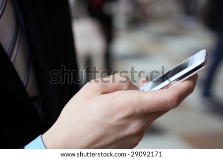 Young businessman typing with cellphone
