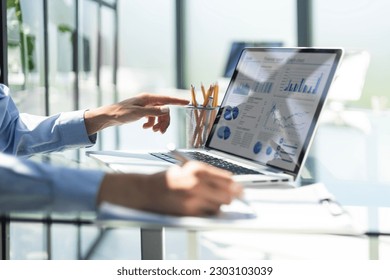 Young businessman typing computer laptop with graph chart for work. - Powered by Shutterstock