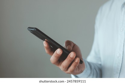 Young businessman using app on a touchscreen smartphone. Concept for using technology, shopping online, using mobile app, texting, phone addiction. mobile phone in business style in the hands of a guy