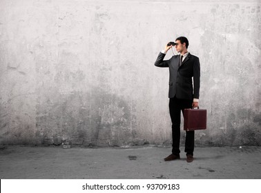 Young businessman using binoculars - Powered by Shutterstock