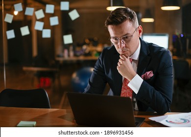 Young businessman using computer in his office. Handsome man working at his workplace