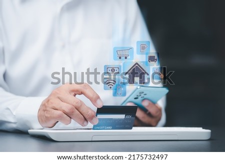 Young businessman is using a credit card to make financial transactions via mobile phone, proportional money management to spend effectively .internet banking, spending money, Consumer society