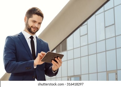 Young Businessman Using A Digital Tablet Outdoors