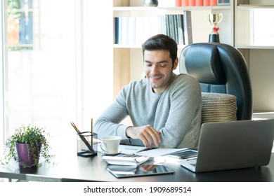 Young Businessman Using Laptop Computer Notebook For Work. Relaxed Young Man Drinking Coffee.