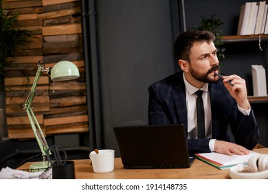 Young businessman using laptop in his office. Businessman taking a notes while working on laptop	
