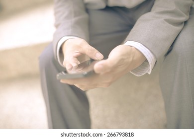 Young businessman using a phone sitting on the stairs - Shutterstock ID 266793818