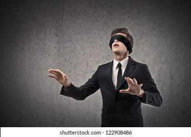 Young businessman walking blindfolded