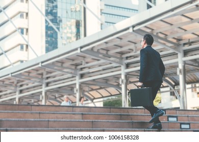 Young businessman walking in city for going to work with cityscape background. - Shutterstock ID 1006158328