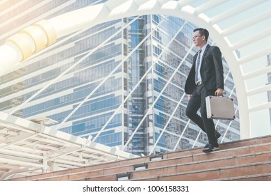 Young businessman walking in city for going to work with cityscape background. - Shutterstock ID 1006158331