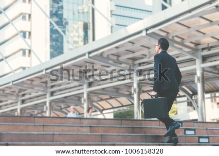 Young businessman walking in city for going to work with cityscape background.
