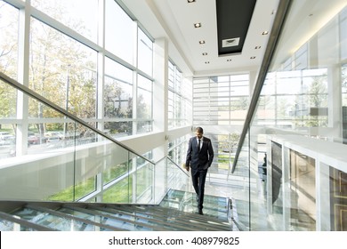 Young Businessman Walking Up The Stairs In The Office Building