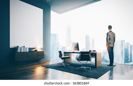 Young businessman wearing modern suit and looking at the city, stands in contemporary office.  - Powered by Shutterstock