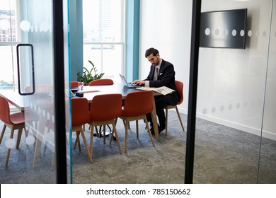 Young Businessman Working Alone In A Boardroom