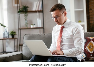 Young businessman working with laptop at office. Businessman sitting on sofa having video call