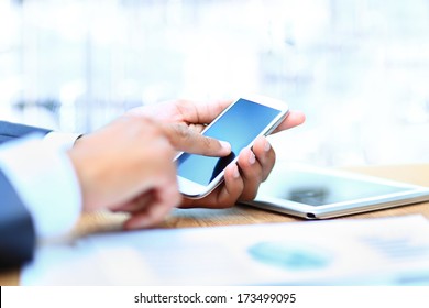 Young businessman working with modern devices, digital tablet computer and mobile phone.