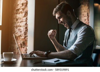 Young Businessman Working On A Plan Of Internet Project On The Laptop. Man Discusses Business Matters By Phone. Working Computer For Internet Research. Digital Marketing. Development