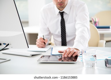 Young businessman working with tablet computer in an office - Shutterstock ID 1186153885