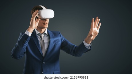 Young Businessman Working In Virtual Reality Office In VR Glasses, Presses His Hand Virtual Interface On Abstract Black Backdrop. Innovate And Future Technology Concept, Close Up