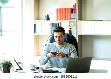 Young Businessmen Are Using Mobile Phones To Scan Documents To Send By App. Man Holding And Using His Mobile Phone. Work From Home.