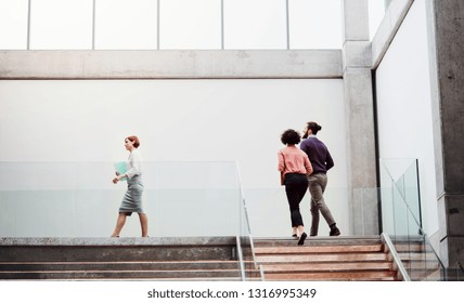 Young Businesspeople At Work, Walking Up The Stairs.